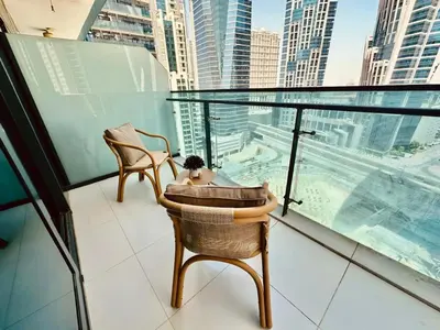 a balcony with chairs and a view of a city at Stylish 1br Merano Tower Pool Parking in Dubai