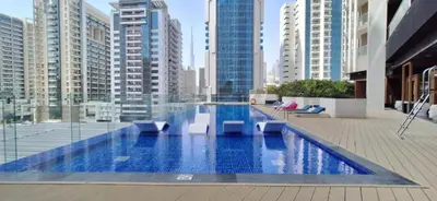 a swimming pool in a city with tall buildings at Stylish 1-Bedroom-Sleeps 4- Apartment -Bayz by Danube, Business Bay-29 in Dubai