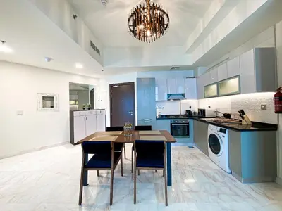 a kitchen with a table and chairs in a room at Stylish 1-Bedroom-Sleeps 4- Apartment -Bayz by Danube, Business Bay-29 in Dubai