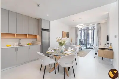 a kitchen and dining room with a table and chairs at Vogue Creek Harbour Creek Crescent Waterfront Living Close to Downtown, Burj Khalifa and Dubai Mall, One Bedroom Apartment with Balcony and City View, Access to all Amenities in Dubai