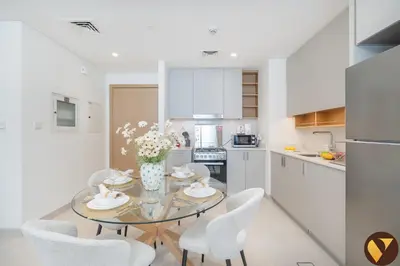 a kitchen and dining room with a glass table and chairs at Vogue Creek Harbour Creek Crescent Waterfront Living Close to Downtown, Burj Khalifa and Dubai Mall, One Bedroom Apartment with Balcony and City View, Access to all Amenities in Dubai