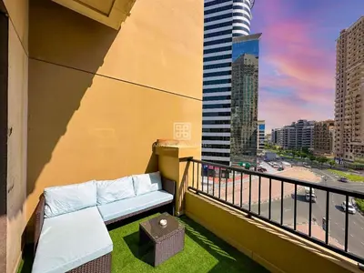 a balcony with a couch and a view of a city at Fully Furnished Studio at Spring Oasis in Dubai Silicon Oasis in Dubai