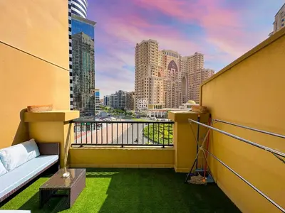 a balcony with a couch and a view of a city at Fully Furnished Studio at Spring Oasis in Dubai Silicon Oasis in Dubai