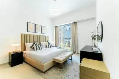 a white bedroom with a large bed and a window at FAM Living Act Two 1BR Walk to Burj & Dubai Mall in Dubai