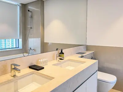 a bathroom with two sinks and a toilet at Dream Shoma Upscale 3BR in Downtown Dubai in Dubai