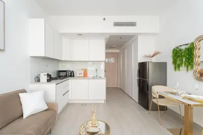 a kitchen and living room with a couch and a table at GuestReady - Rooftop Pool l Garden l Nice Balcony in Dubai