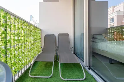 two benches on a balcony with green plants at GuestReady - Rooftop Pool l Garden l Nice Balcony in Dubai
