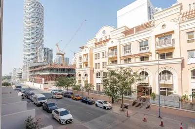 a city street with cars parked in front of buildings at GuestReady - Rooftop Pool l Garden l Nice Balcony in Dubai