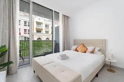 a bedroom with a white bed and a large window at GuestReady - Rooftop Pool l Garden l Nice Balcony in Dubai