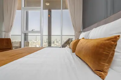 a bedroom with a large bed with a large window at BLVD - Upgraded Highrise Suites in Dubai