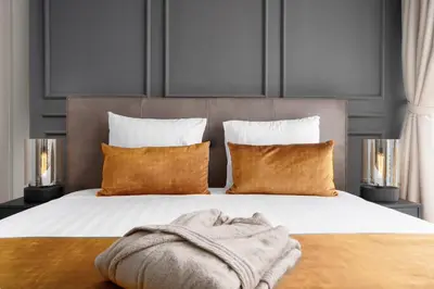 a bed with a blanket on it with two lamps at BLVD - Upgraded Highrise Suites in Dubai