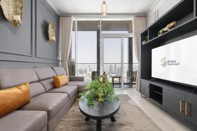 a living room with a couch and a flat screen tv at BLVD - Upgraded Highrise Suites in Dubai