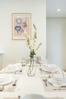 a white table with a vase with flowers in it at Luxury unit in the Heart of Dubai Hills in Dubai