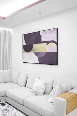 a living room with a white couch and a painting on the wall at Romantic basic apertmen in Dubai