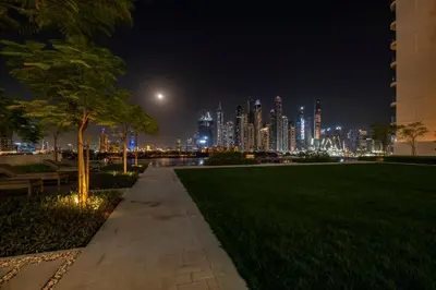 a park with a view of a city at night at Romantic basic apertmen in Dubai