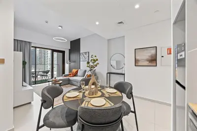 a kitchen and living room with a table and chairs at Dreamy Apartment,Pool with Burj khalifa View ,5Min Walk to Dubai Mall in Dubai