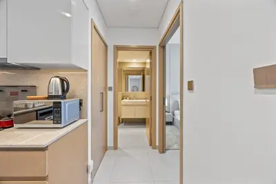 a kitchen with a microwave on a counter next to a room at Dreamy Apartment,Pool with Burj khalifa View ,5Min Walk to Dubai Mall in Dubai