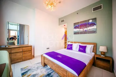 a bedroom with a bed with purple pillows and a mirror at Stylish 2BR in Continental Tower Dubai Marina in Dubai