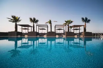 a large swimming pool with palm trees in the background at Vacationer I JVC Gem 1 Bedroom I Free Pool, Gym, Parking & Wi-Fi in Dubai