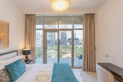 a bedroom with a bed and a large window at Vacationer I JVC Gem 1 Bedroom I Free Pool, Gym, Parking & Wi-Fi in Dubai