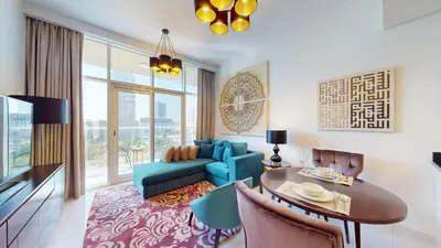 a living room with a blue couch and a table at Vacationer I JVC Gem 1 Bedroom I Free Pool, Gym, Parking & Wi-Fi in Dubai