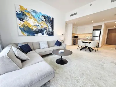 a living room with a couch and a table at SUNRISE HOMES - Stylish 1-BR with Incredible Views - Creekside in Dubai