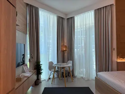 a hotel room with a bed and a table and window at Cozy Studio with Balcony Pool View - Business Bay in Dubai