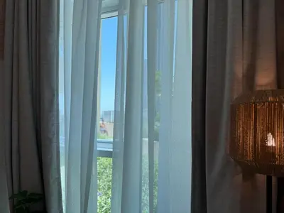 a room with a window with curtains and a lamp at Cozy Studio with Balcony Pool View - Business Bay in Dubai