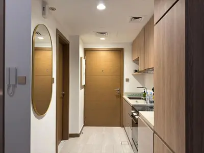 a kitchen with a hallway with two wooden doors at Cozy Studio with Balcony Pool View - Business Bay in Dubai