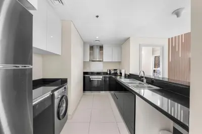 a large kitchen with black and white appliances at Luxury Apartment 2BR with Sea & Palm View - DAMAC Heights in Dubai