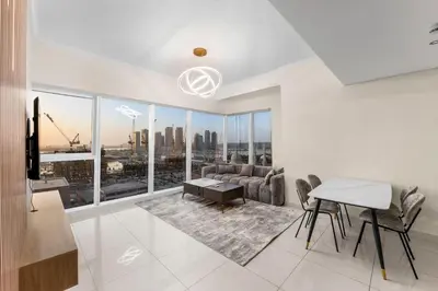 a living room with a view of a city at Luxury Apartment 2BR with Sea & Palm View - DAMAC Heights in Dubai