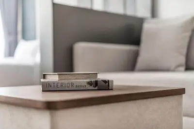 two books sitting on a coffee table in front of a couch at DAYF-SER08 Brand New Studio with Balcony in JVC in Dubai