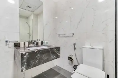 a white bathroom with a sink and a toilet at DAYF-SER08 Brand New Studio with Balcony in JVC in Dubai