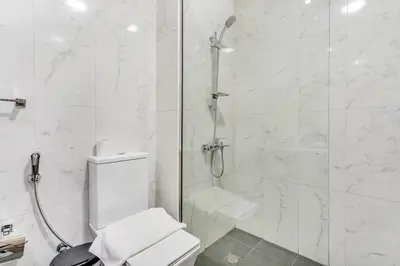 a white bathroom with a shower and a toilet at DAYF-SER08 Brand New Studio with Balcony in JVC in Dubai