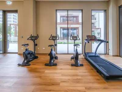 a gym with several treadmills and a treadmill at 1BD Apartment at Creek Beach with Lagoon Access in Dubai