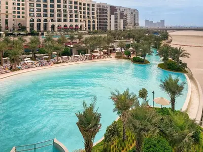 a large swimming pool with a beach and buildings at 1BD Apartment at Creek Beach with Lagoon Access in Dubai