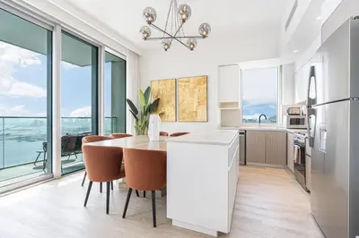 a kitchen with a table and chairs and a large window at Stunning Home with Creek and Downtown Views in Dubai