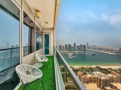 a balcony with two chairs and a view of the city at Amazing Design Colorfull Flat Palm Jumeirah View in Heart of Marina in Dubai