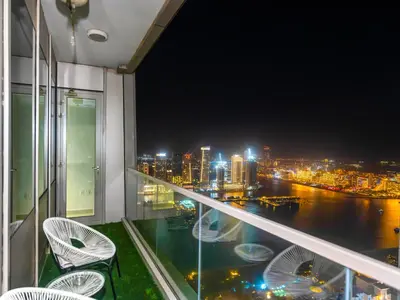 a balcony with a view of the city at night at Amazing Design Colorfull Flat Palm Jumeirah View in Heart of Marina in Dubai