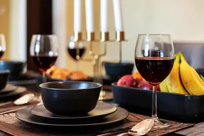 a table with two glasses of wine and a bowl of fruit at Cozy 2BDR Residence in Dubai's Souk Al Bahar in Dubai
