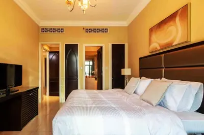 a bedroom with a large bed and a flat screen tv at Cozy 2BDR Residence in Dubai's Souk Al Bahar in Dubai