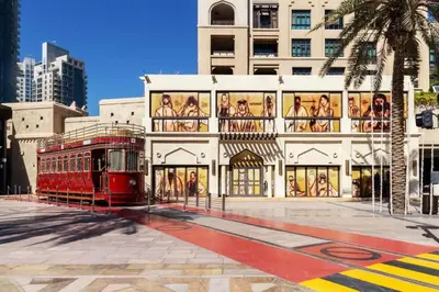 a building with a red trolley in front of it at Cozy 2BDR Residence in Dubai's Souk Al Bahar in Dubai
