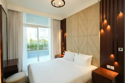 a bedroom with a white bed and a window at Vera Tower - 2 Bedroom with Burj Khalifa view in Dubai
