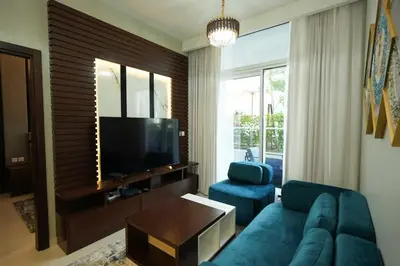 a living room with a blue couch and a television at Vera Tower - 2 Bedroom with Burj Khalifa view in Dubai