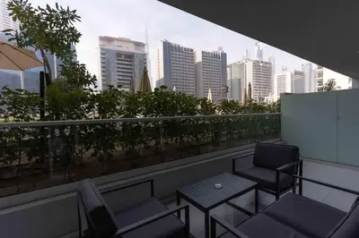 a balcony with chairs and a table and a city skyline at Vera Tower - 2 Bedroom with Burj Khalifa view in Dubai