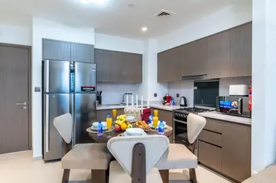 a kitchen with a table and chairs and a refrigerator at The 34th Perch Downtown Retreat 2BDR in Dubai