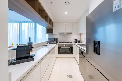 a kitchen with white counters and a large window at Ultimate Luxury 3BDR With Burj Khalifa view in Dubai