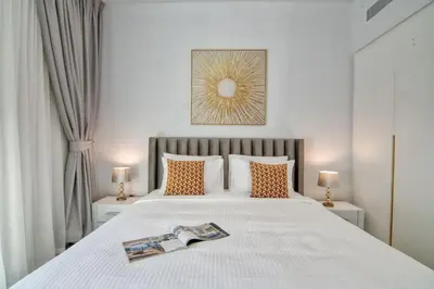 a bedroom with a bed with a magazine on it at LA VIE 1BDR in JBR with Private Beach in Dubai
