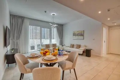a dining room and living room with a table and chairs at LA VIE 1BDR in JBR with Private Beach in Dubai