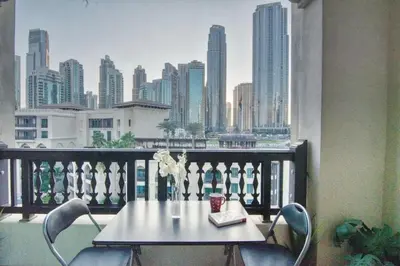 a table on a balcony with a view of a city at Gorgeous 1BDR with Burj Khalifa & Fountain Views in Dubai